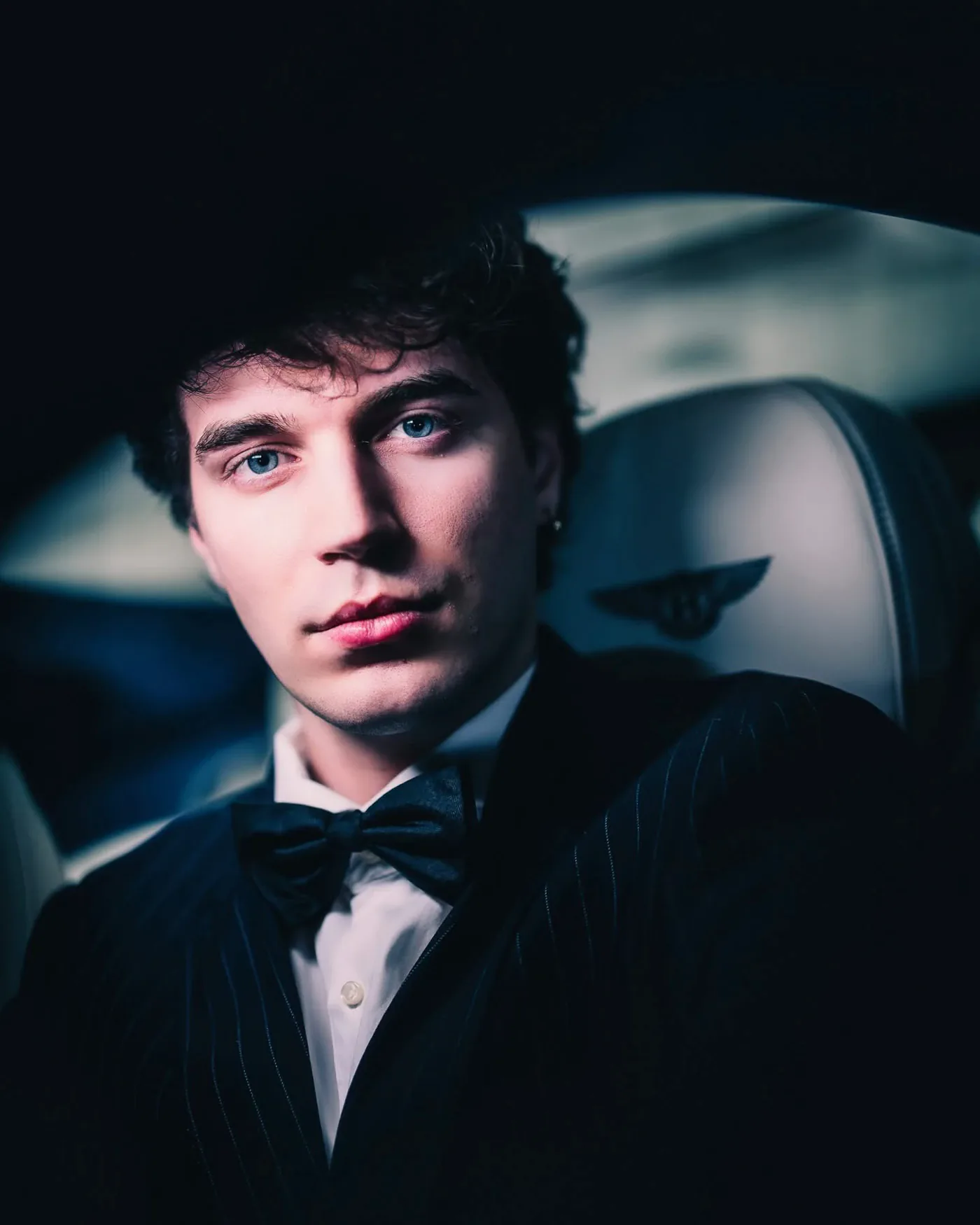 Primo piano in smoking e papillon all’interno di un’auto, luce drammatica laterale