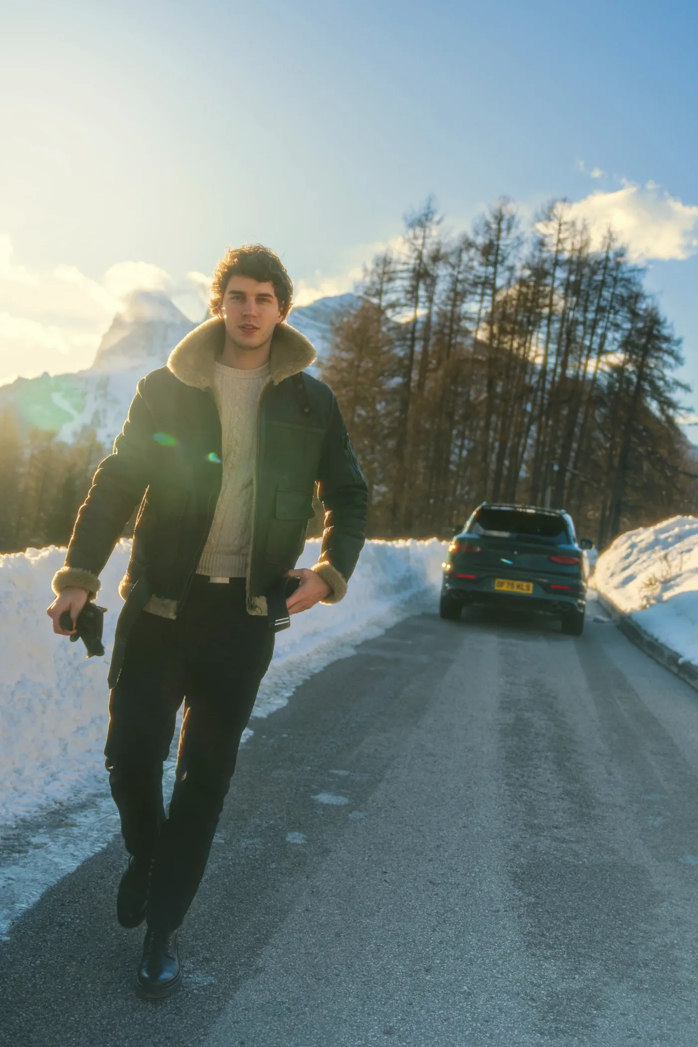 Francesco Scarparo cammina in controluce su una strada innevata a Cortina